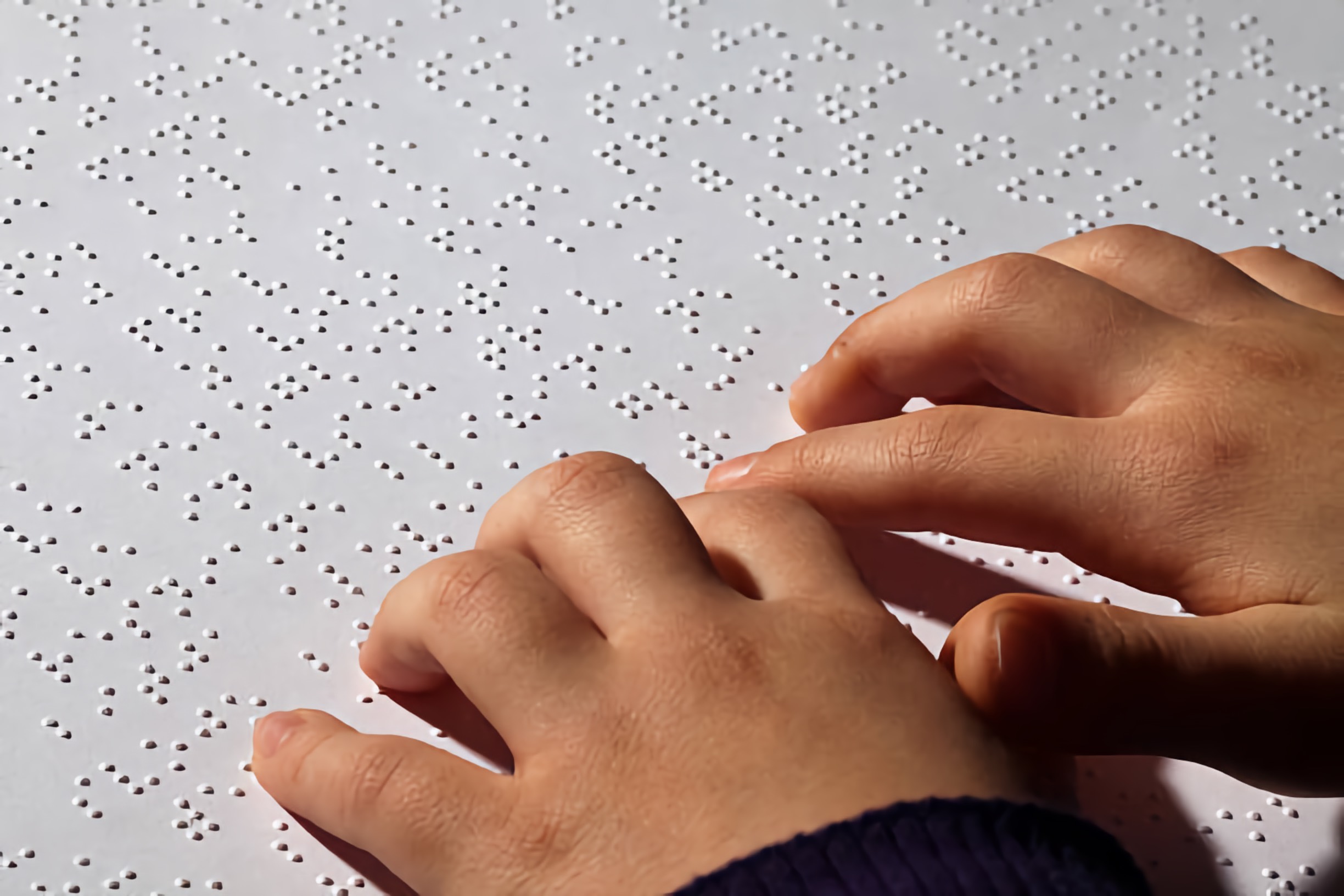 Child hands reading Braille
