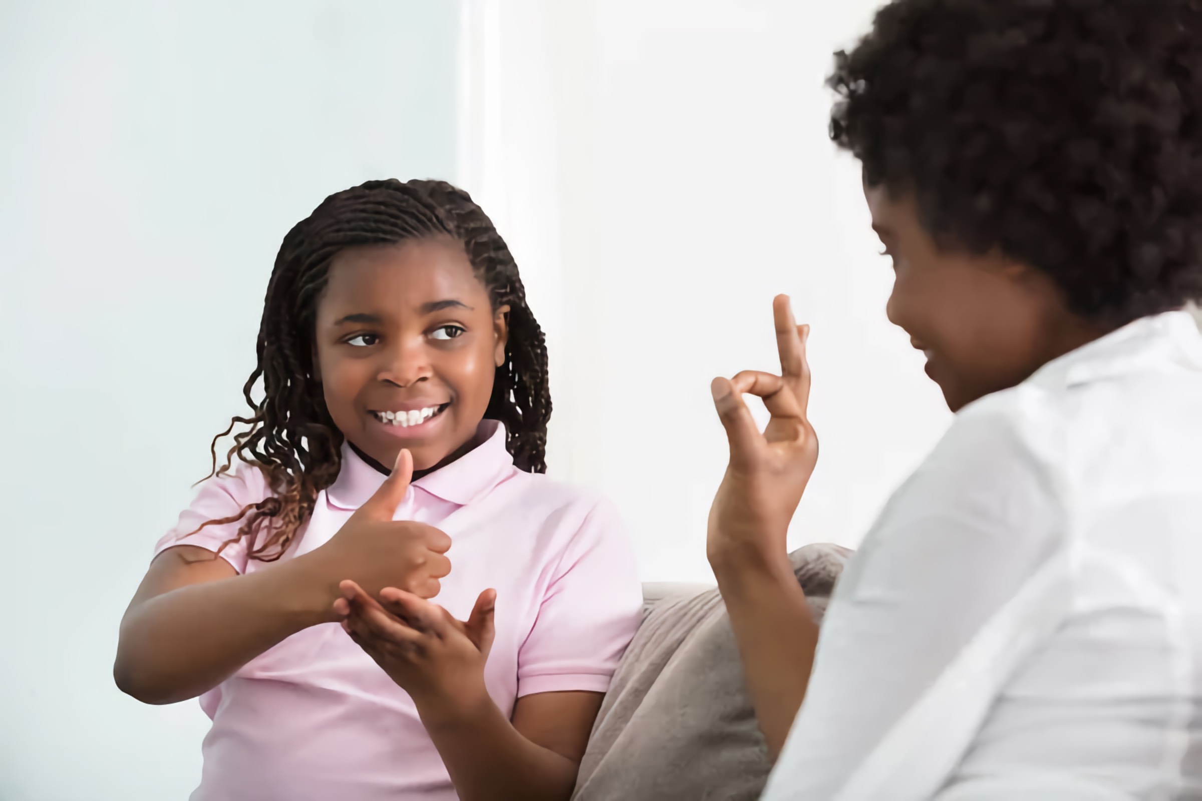 Communication between a Black mother and daughter using American Sign Language (ASL)