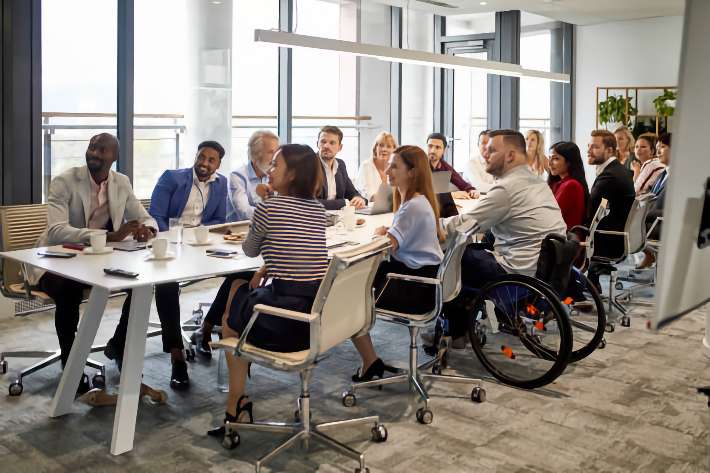 Large diverse meeting at a long table including People with Disabilities