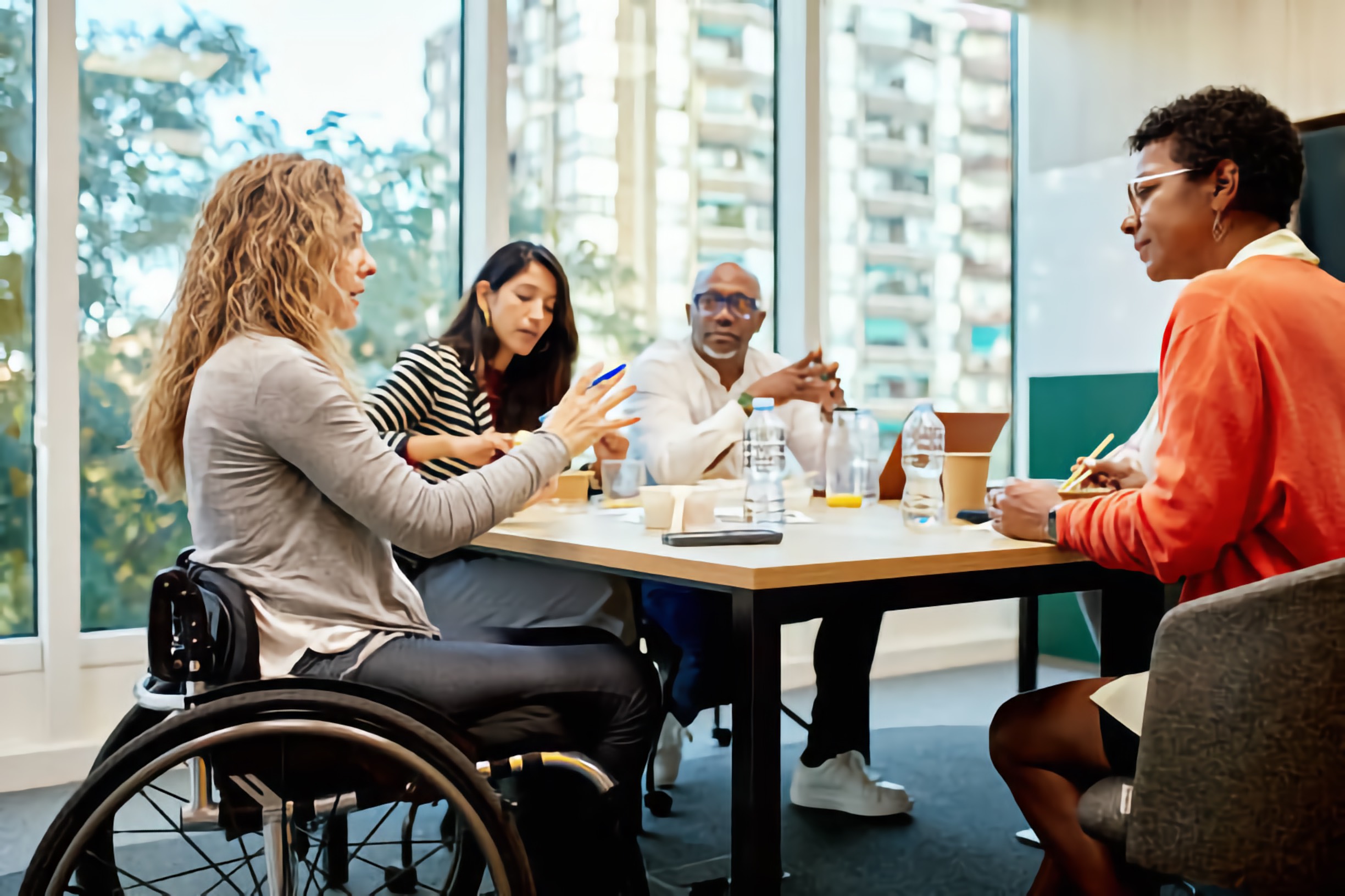 A diverse work group, including a woman in a wheelchair, meeting and consulting