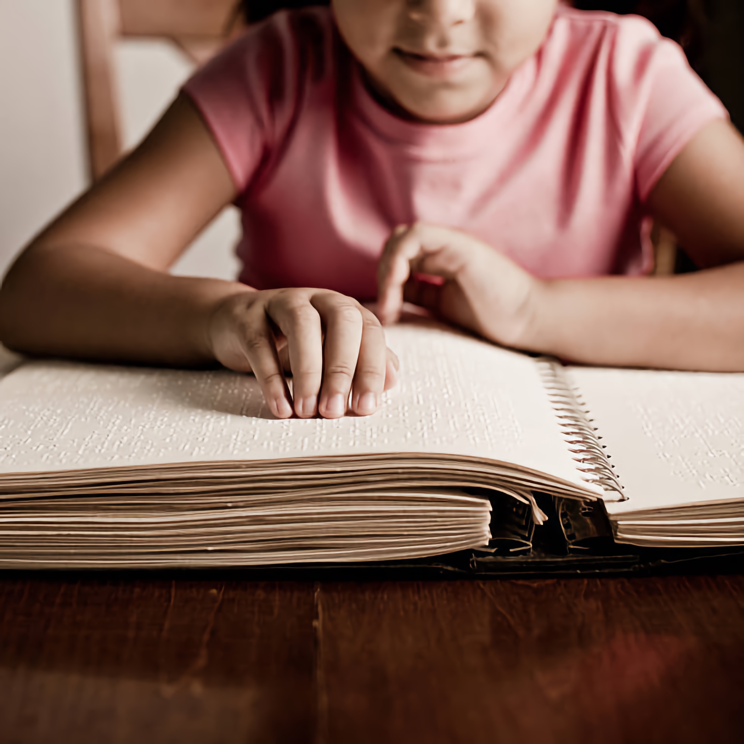 A young girl reading a Braille Book.