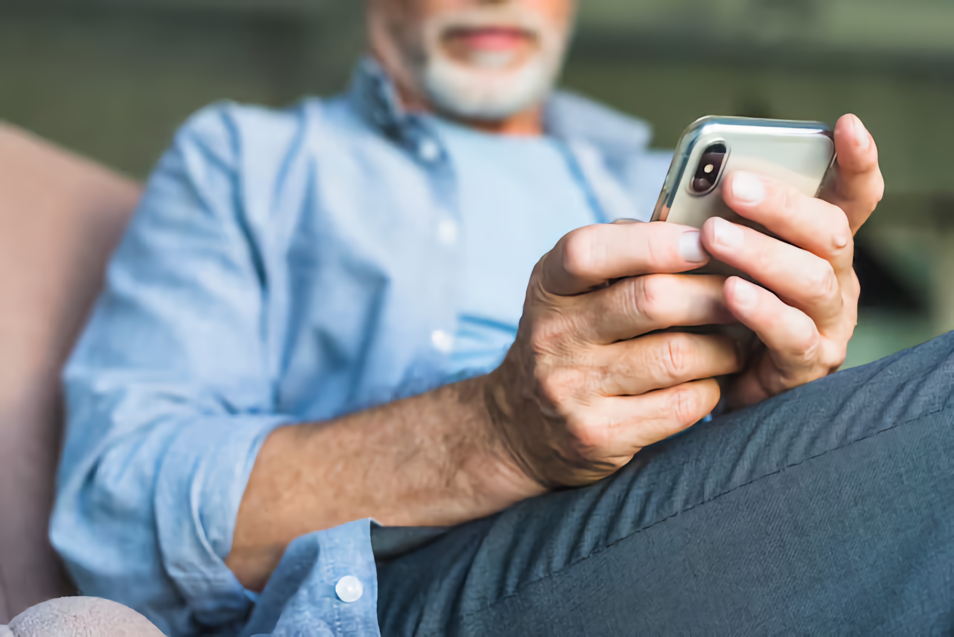 Close-up of an older man accessing information on a smartphone.