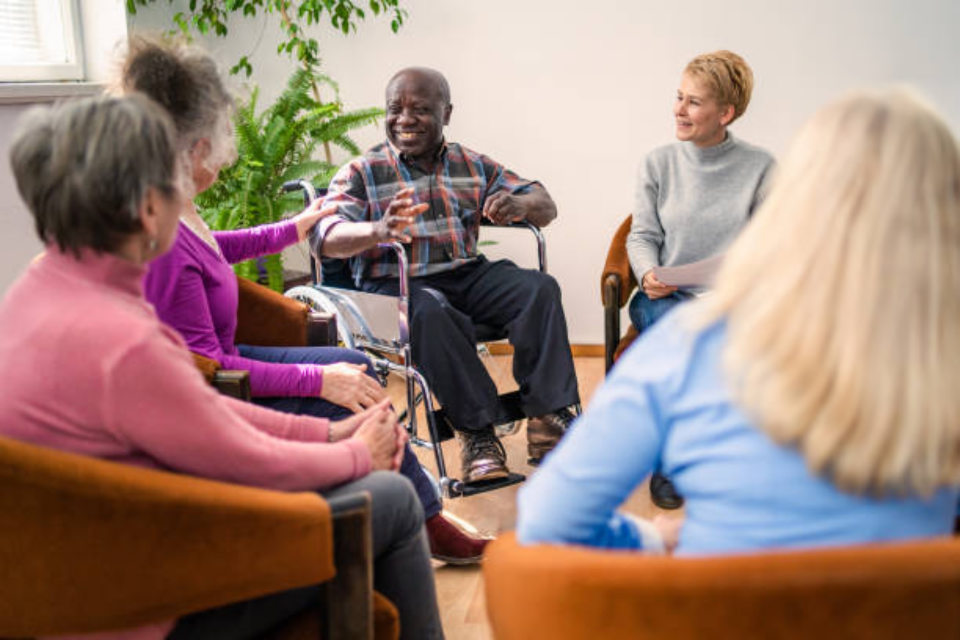 A Black man who uses a wheelchair is able to participate in an accessible community meeting