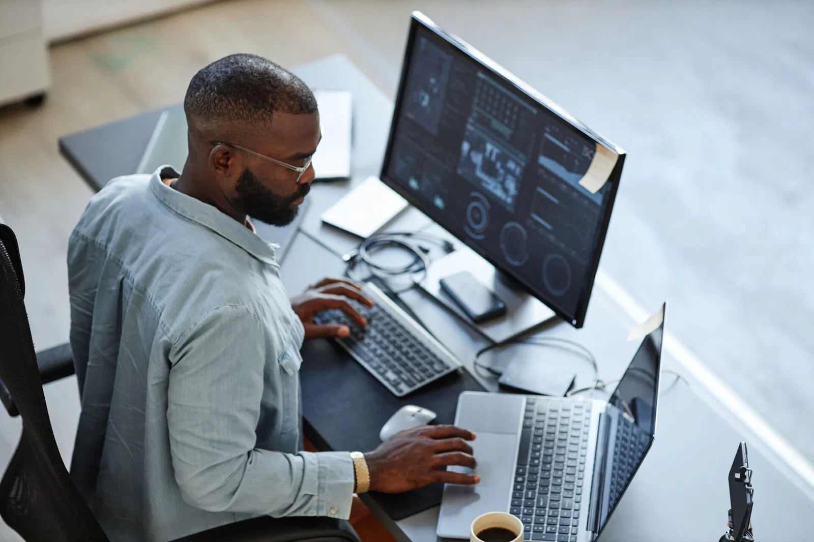 Developer reviews dashboards on laptop and monitor, suggesting a website accessibility audit.